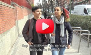A screenshot of a Spanish video showing two young students walking together. There's a caption that reads. "Hoy es el primer día de clase después de Navidad"