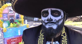 A Mexican man with his face painted as a skull