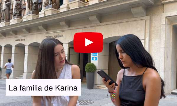 An image from a video that features two Hispanic girls: one is holding a cellphone on her hand. There's a titles that reads "La familia de Karina"